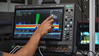 Engineer using an oscilloscope for signal analysis.