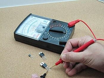 an analog multimeter testing an electronic component